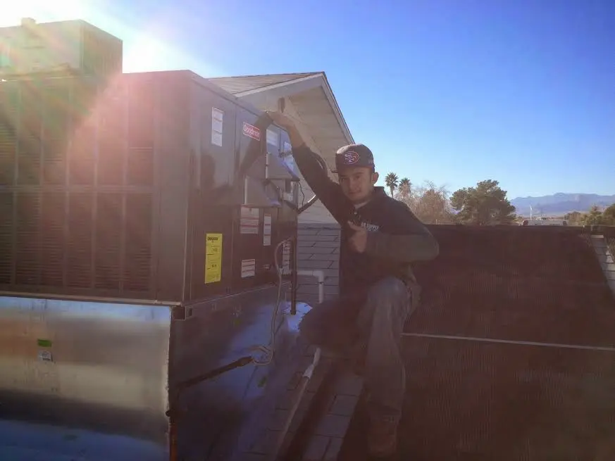 HVAC technician performing HVAC Inspection on a rooftop unit in Four Corners